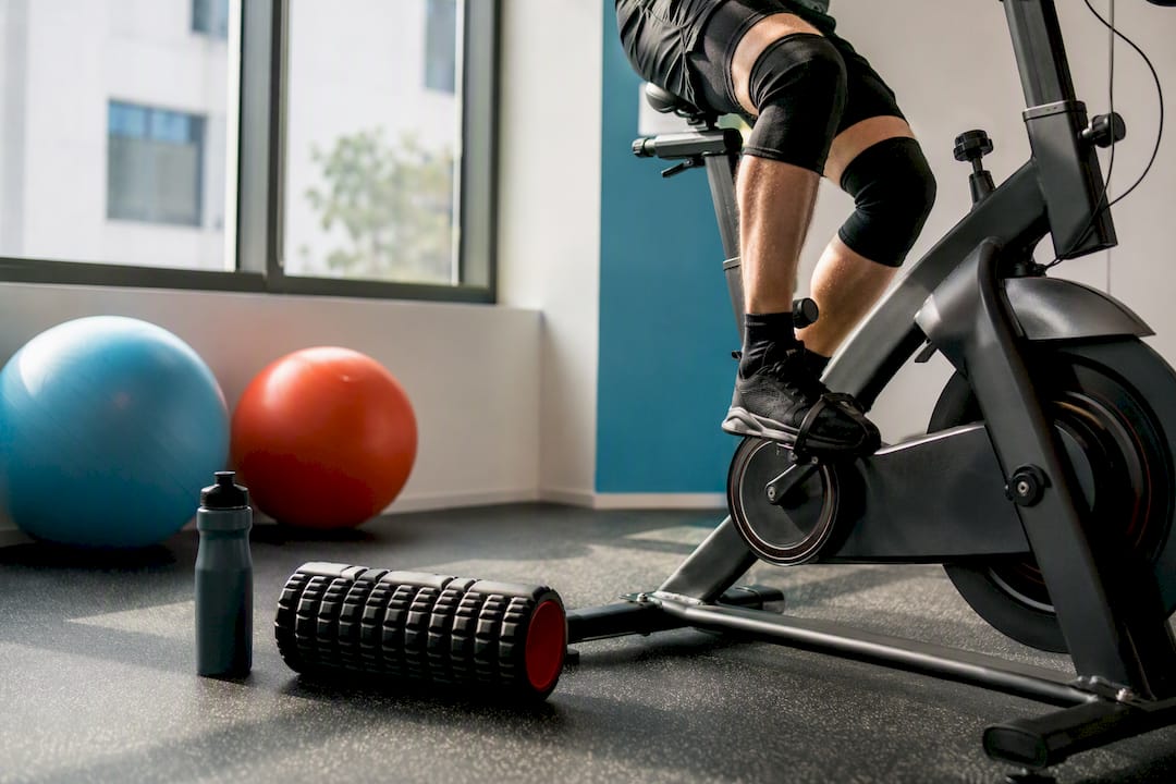 Cyclist legs pedaling stationary bike