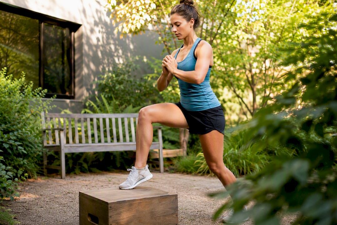 Runner doing controlled step-up exercise for knee rehab