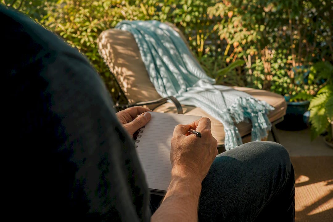 Hands tracking hip pain flare triggers with notebook