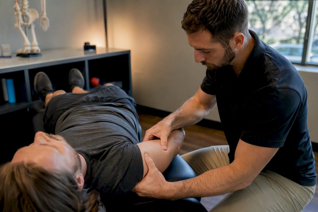 Hands applying fascial distortion therapy on elbow