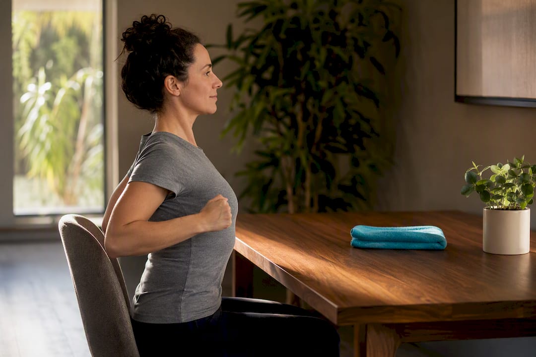 Adult performing seated scapular exercise