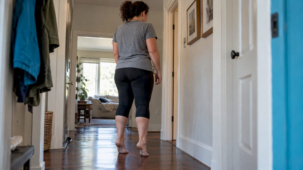 Person performing home heel loading exercise