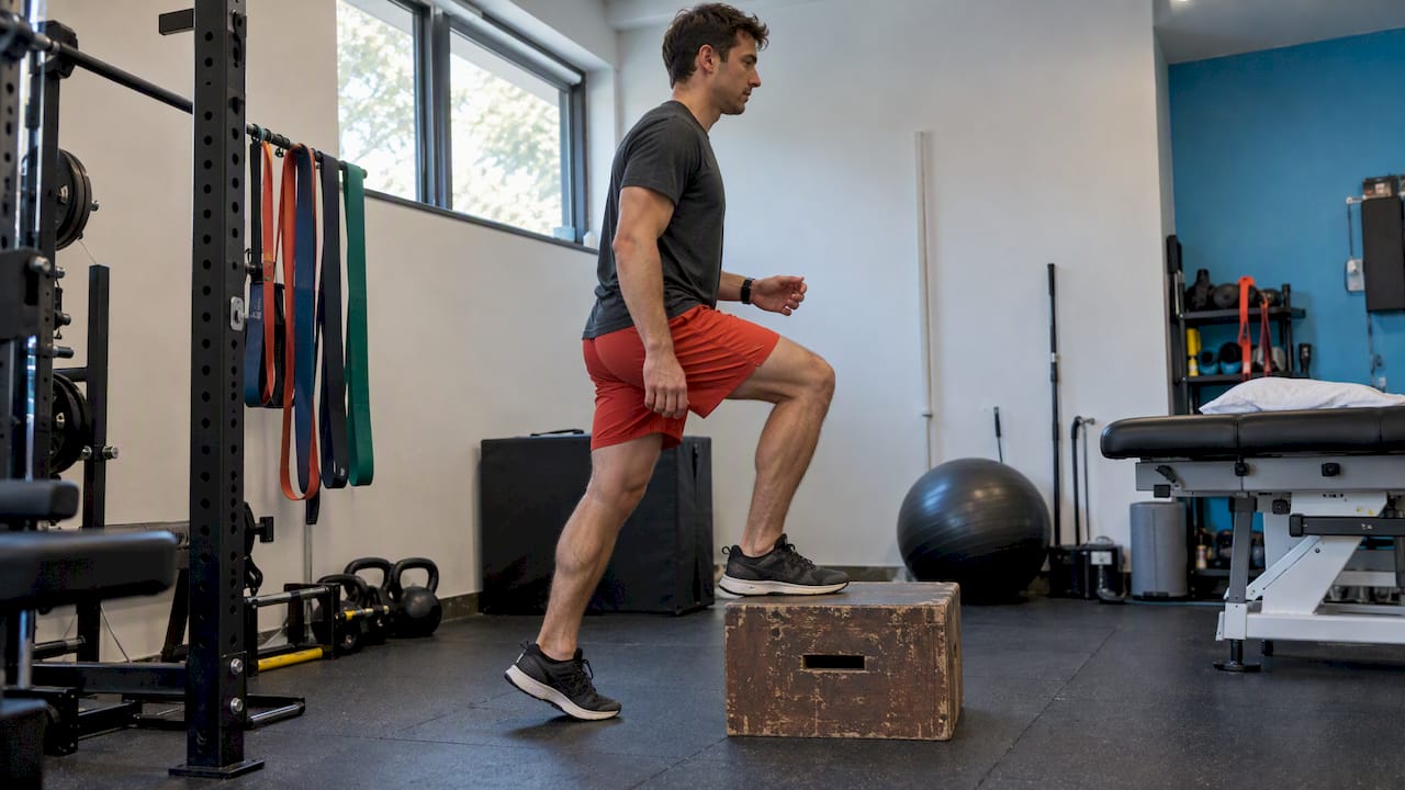 Runner performing a controlled step-up exercise