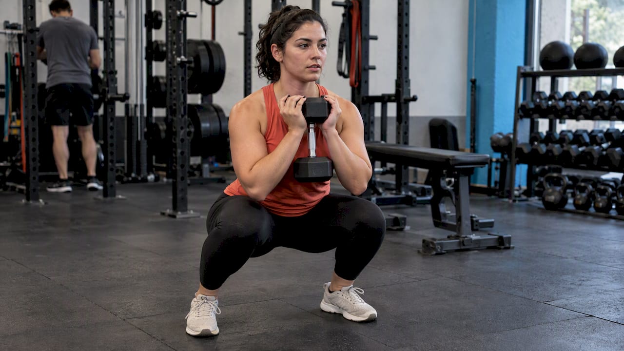 Athlete checks knee and hip alignment during squat